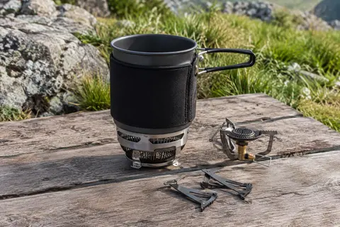 Réchaud compact Fire-Maple FMS-X3 avec casserole de 0,8 L posé sur une table de bivouac en bois
